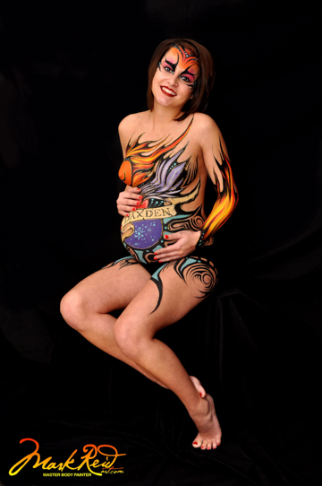 seated dark haired model who is pregnant cupping her belly and fully painted